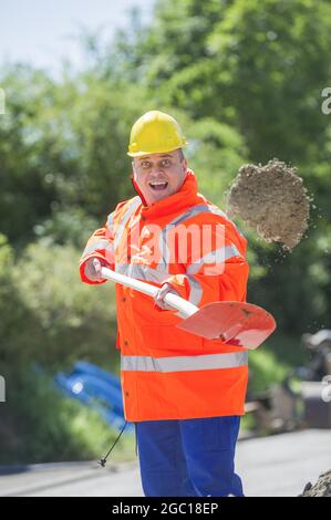 construction worker shoveling sand Stock Photo