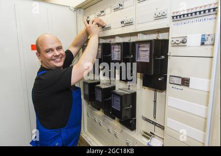 electrician at the distribution cabinet Stock Photo