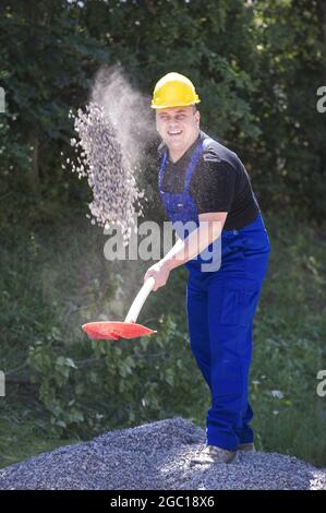 construction worker shoveling sand Stock Photo