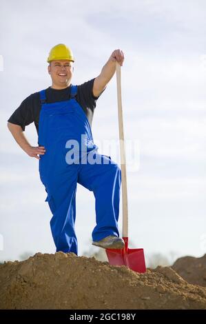 construction worker shoveling sand Stock Photo