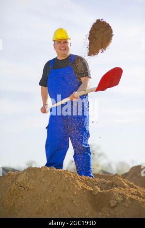 construction worker shoveling sand Stock Photo