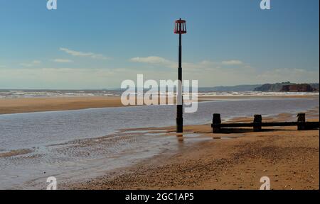 A groyne and marker beacon on Dawlish Warren beach at low tide. Stock Photo