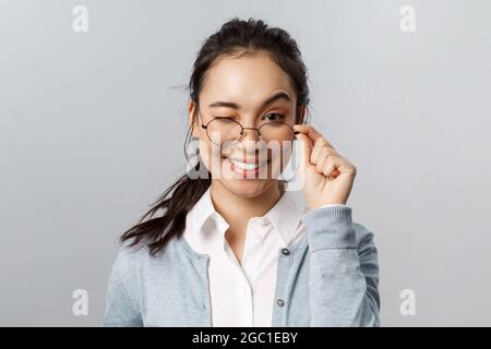 Advertisement, people and emotion concept. Close-up of cheeky smiling asian brunette female guarantee you will like this product, wink flirty and Stock Photo