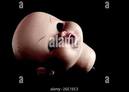 Doll head on black background Stock Photo