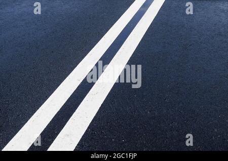 Double solid white line on wet asphalt Stock Photo