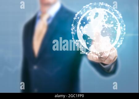 Businessman point at earth globe hologram. Man hand with earth, concept of global network communication and business. Elements of this image furnished Stock Photo