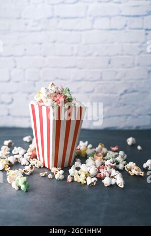 popcorn spilling from a container on a table  Stock Photo