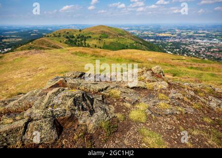 The granite rocks of Worcestershire Beacon with North Hill in the background, Malvern Hills, Worcestershire, England Stock Photo