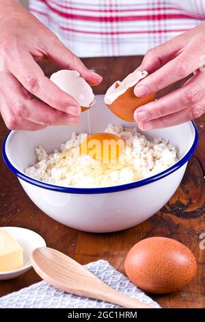 Making a shortcrust pastry adding egg to the flour Stock Photo