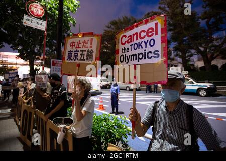 Tokyo, Japan. 06th Aug, 2021. People hold signs as they stage a protest against the 2020 Summer Olympics outside Olympic Stadium on August 6, 2021, in Tokyo, Japan. Tokyo was to host the 2020 Summer Olympic Games on July 24-August 9, 2020. The games were postponed for a year due to the COVID-19 pandemic. Credit: Ondrej Deml/CTK Photo/Alamy Live News Stock Photo