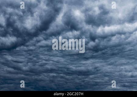 Dark sky, white fluffy and rainy dark clouds before rain. Background texture. Stock Photo