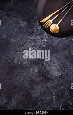 Clean empty black plate with cutlery. Copy space, mock up, top view. Concept for menu with utensil. Stock Photo