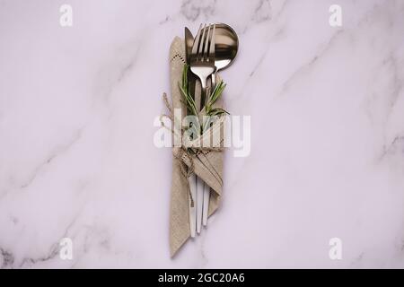 Cutlery set. Stylish white cutlery at  napkin. Top view on kitchen table. Stock Photo