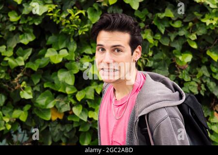 shocked young man surprised on a green plants background, concept of human expressions and emotions, copy space for text Stock Photo