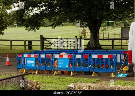 men at work repairing a leaking water main in a rural village in the southwest of UK Stock Photo