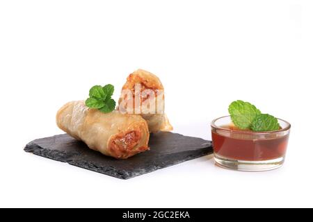 Spring rolls with nuoc mam sauce and mint leaves on a white background Stock Photo