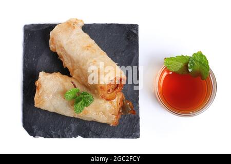 Spring rolls with nuoc mam sauce and mint leaves on a white background Stock Photo