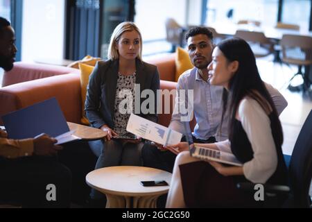 Diverse group of business colleagues using laptop and having meeting Stock Photo