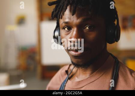 Portrait of african american male painter at work wearing headphones in art studio Stock Photo