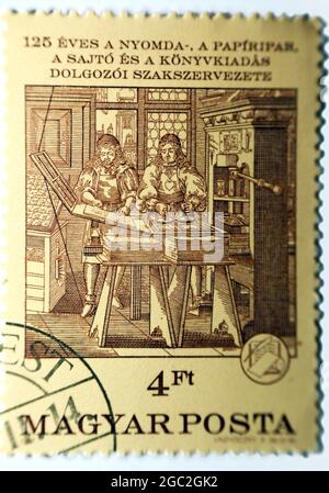 A cancelled postage stamp printed by Hungary for 125th Anniversary of the Hungarian Press Workers' Union, Hungarian Printing, Paper shows Printing Sho Stock Photo