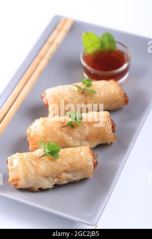 Spring rolls with nuoc mam sauce and mint leaves on a white background Stock Photo
