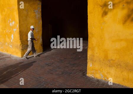 Local striding by the Boca del Puente and Clock Tower Monument at the main entrance to the old walled city of Cartagena, Colombia. Stock Photo