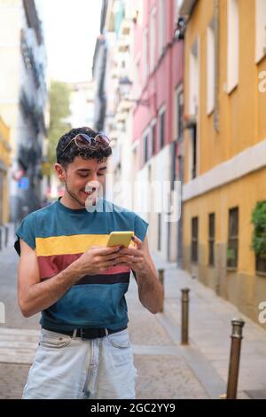 Young caucasian man with false nails using the phone on a street. Stock Photo