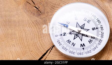 Close-up of compass on wooden background with place for text. Stock Photo