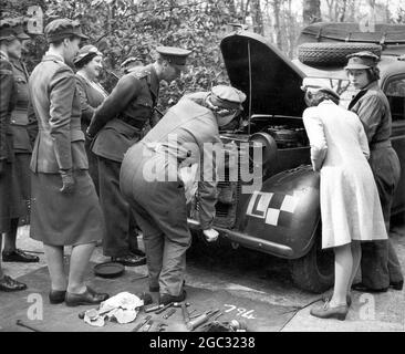 Princess Elizabeth trains as an ATS officer 2nd Subaltern undergoes training as a mechanic. Visited by King George VI the Queen Mother and Princess Margaret. 12th April 1945 Clad in her ATS overralls. Princess Elizabeth shows off her newly acquired vehicle maintenance skills to her parents and sister Margaret. Stock Photo