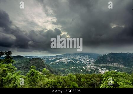 Green hills with trees under the dark cloudy sky Stock Photo - Alamy