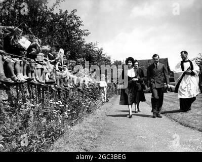 School Children wave a greeting to Princess Elizabeth as she arrives at the church of Mersham Kent for the christening of Michael John Ulick the second son of Lord and lady Bradbourne escorted by Lord Brabourne 26 June 1950 The queen is to be godmother Stock Photo