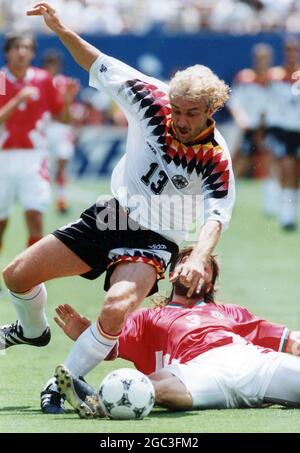 German World Cup star Rudi Voller tackled by a Bulgarian player during the 1994 FIFA World Cup Stock Photo