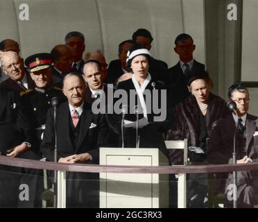 The Queen making her speech before pulling the switch which brought into operation Calder Hall, the world's first full scale atomic power station, near Sellafield, Cumberland 17 October 1956. With the Queen on the dais are Mr R. A. Butler, Lord Privy Seal (left) and Sir Edwin Plowden, Chairman of the United Kingdom Atomic Energy Authority (right). The Â£16 1/2 million plant is now switched in to the national electricity grid. Colourised photograph Stock Photo