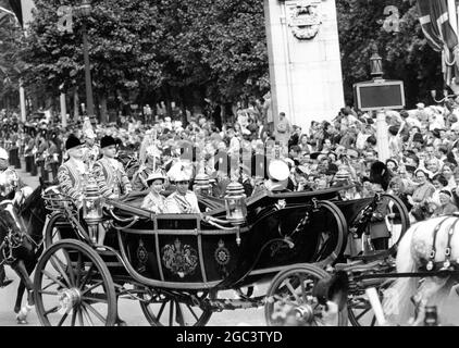 16 July 1956 King Faisal II of Iraq drives in an open carriage with Queen Elizabeth II from Victoria Station to Buckingham Palace, London, for a State visit to England. It is the first State visit by an Iraqi monarch. Stock Photo