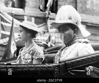 16 July 1956 King Faisal II of Iraq drives in an open carriage with Queen Elizabeth II from Victoria Station to Buckingham Palace, London, for a State visit to England. It is the first State visit by an Iraqi monarch. Stock Photo