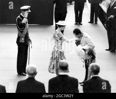 16 July 1956 The Duke of Edinburgh salutes as King Faisal II of Iraq bends down to kiss the hand of Queen Elizabeth II on his arrival at Victorial Station, London, for a State visit to England. It is the first State visit by an Iraqi monarch. Stock Photo