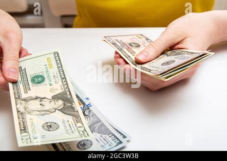 Female hands count a bundle with dollars, shift from one side to another, the concept of financial independence. Stock Photo