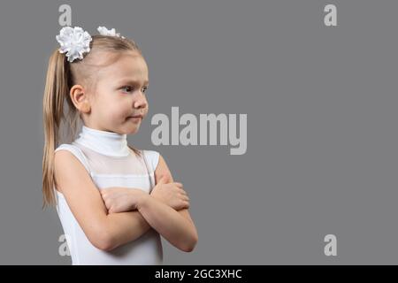 Portrait of a beautiful caucasian little displeased girl arms folded, closed pose. The idea of child discontent on the actions of adults. Place for te Stock Photo