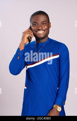 handsome, happy young african man smiling while making a phone call Stock Photo