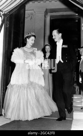 The Queen leaves after the ball London : The Queen , in a gown of silver brocade and wearing a diamond necklace and a diamond and emerald tiara , pauses to chat with the Earl of Leicester as she leaves Londonderry Hosue where she attended her first ball of the season. The party was the coming-out ball for Lady Annabel Stewart , daughter of the Marquess of Londonderry , and Lady Carey Coke , daughter of the Earl of Leicester 9 July 1952 Stock Photo