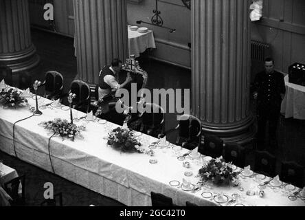 Behind the scenes at a state banquet. Homecoming banquet for Queen Elizabeth II at the Mansion House, London after her Commonwealth Tour in 1954. The catering firm of Ring & Brymer (Birch’s) Ltd have handled the catering at every Coronation banquet given by the Corporation of London since Queen Victoria’s Coronation and have catered for more crowned heads than any other firm in the world. 19 May 1954 Photo shows: The Queen’s Own Chair gets a good dust and brush-up Stock Photo