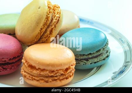 Assorted colorful macaroons on plate in white background. Stock Photo