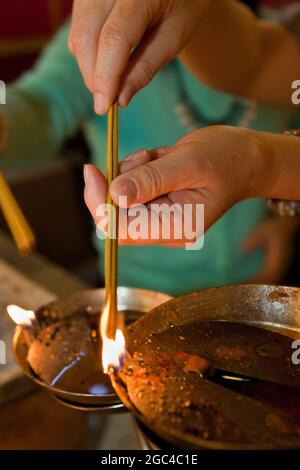 Worshipers light candles and incense at Man Mo Temple in Hong Kong, China Stock Photo