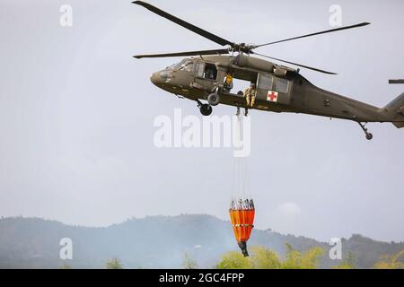 A UH-60 Black Hawk helicopter prepares to land at an open field at Gurabo, Puerto Rico, May 22, 2021. The Governor of Puerto Rico, Pedro Pierluisi, activated the National Guard in support of the Puerto Rico Fire Department to fight fires in the municipalities of Gurabo and Cayey to protect residents' health, well-being, and property. (U.S. Army National Guard photo by Staff Sgt. Marimar Rivera Medina) Stock Photo