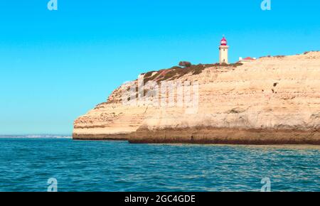Alfanzina Lighthouse over the rock cliffs near Benagil, in Algarve, Portugal Stock Photo