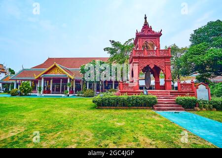 The scenic red building of Ho Rakang bell tower, located amid the lawn in Wat Phra That Hariphunchai Temple, Lamphun, Thailand Stock Photo