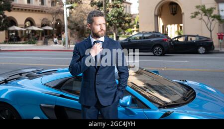 successful dealer in blue business suit at super car outdoor, dealership Stock Photo