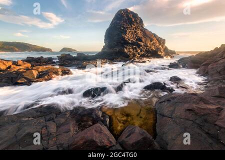 water flowing onto the rocks at sunrise Stock Photo