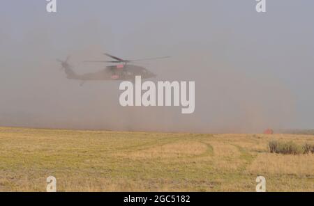 An Oregon Army Guard HH-60M Black Hawk helicopter lands after first setting its attached water bucket on the ground at the Brattain Helibase on September 15, 2020 near Lakeview, Ore for refueling. Two Oregon Guard Black Hawks, headquartered out of Salem, Ore. are currently assigned to the fire. The helicopters concentrated on dumping water buckets on the north perimeter of the fire in coordination with other aircraft supporting wildland firefighting efforts. The Brattain Fire started on September 7, 2020. (National Guard photo by Maj. Leslie Reed, Oregon Military Department Public Affairs). Stock Photo