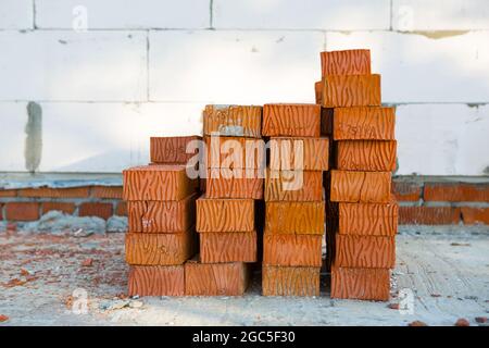 A stack of red bricks at a construction site. Construction materials, delivery, warehouse. Copy space Stock Photo